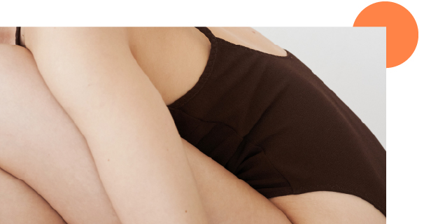 Corps d'une femme en body recroquevillée sur elle même