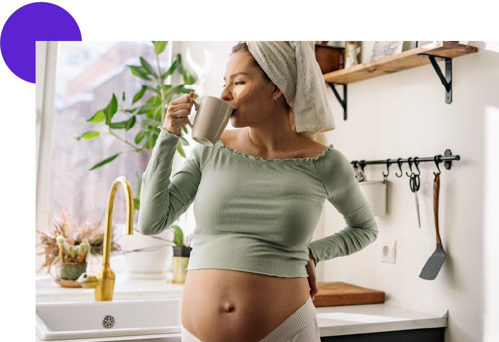 femme enceinte qui boit un café dans sa cuisine