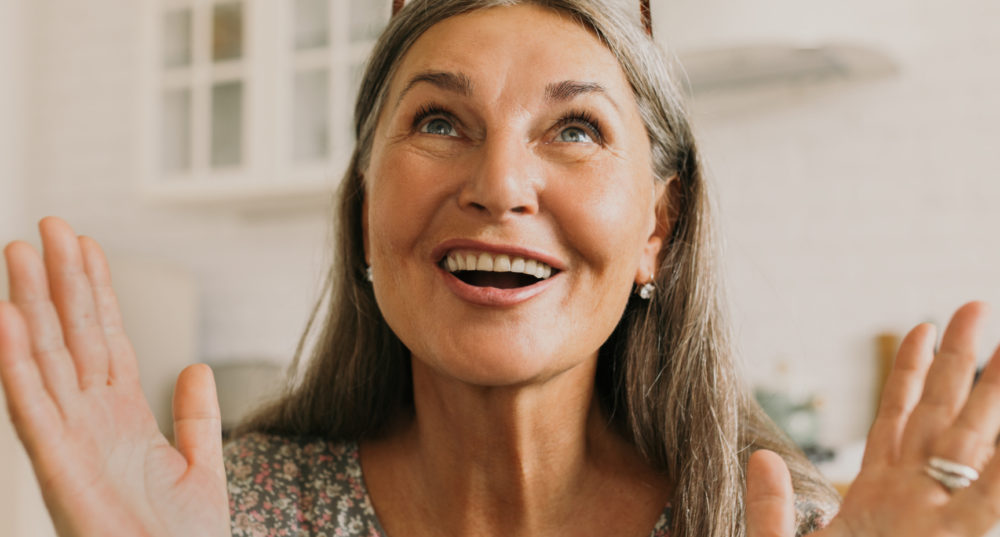 Femme aux cheveux gris ravie d'en finir avec les fripés de peau grâce à la médecine esthétique