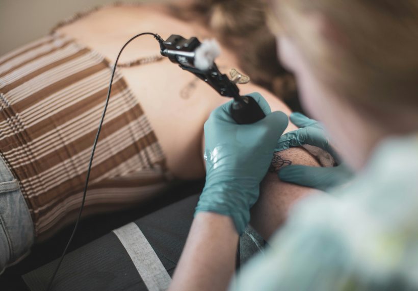 Séance de tatouage sur le haut du bras d'une femme
