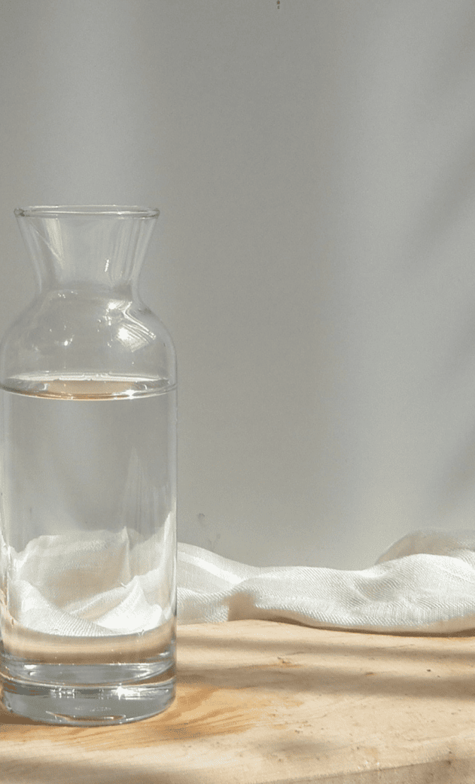 une personne qui prend une bouteille d'eau au travail pour boire et diminuer sa cellulite