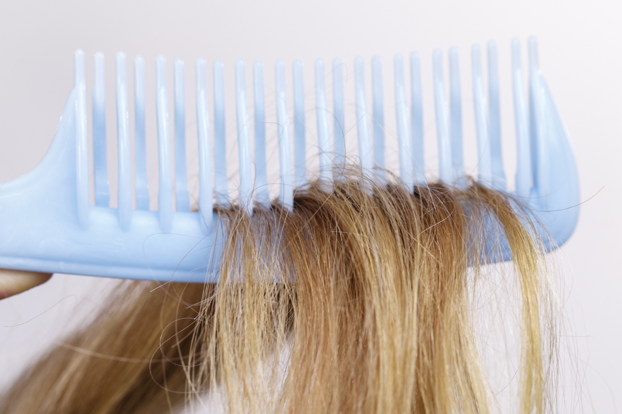 Une personne qui a des cheveux très secs à cause des dommages extérieurs de l'été