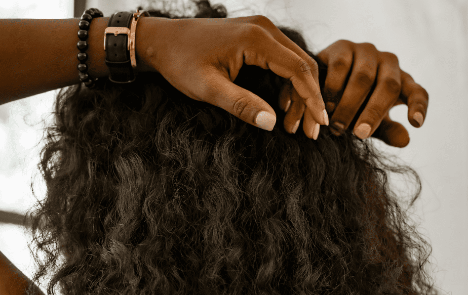 Une femme noire qui a des cheveux très abîmés à cause des rayons UV du soleil