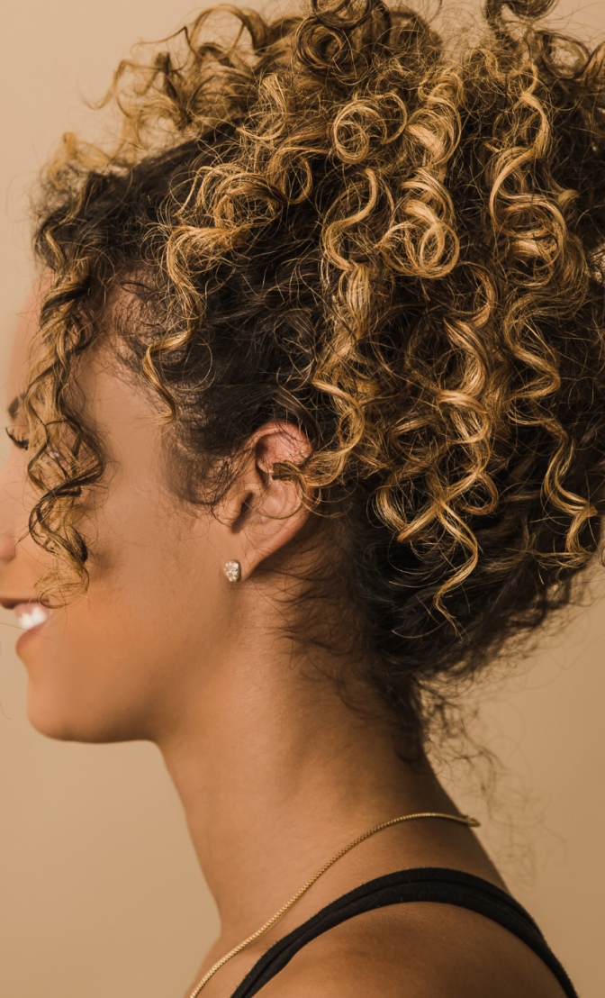 une femme noire qui a des cheveux bouclés