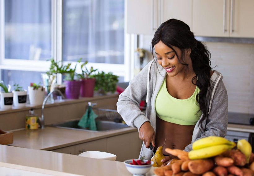 fille qui coupe des fruits et légumes pour un jus détox