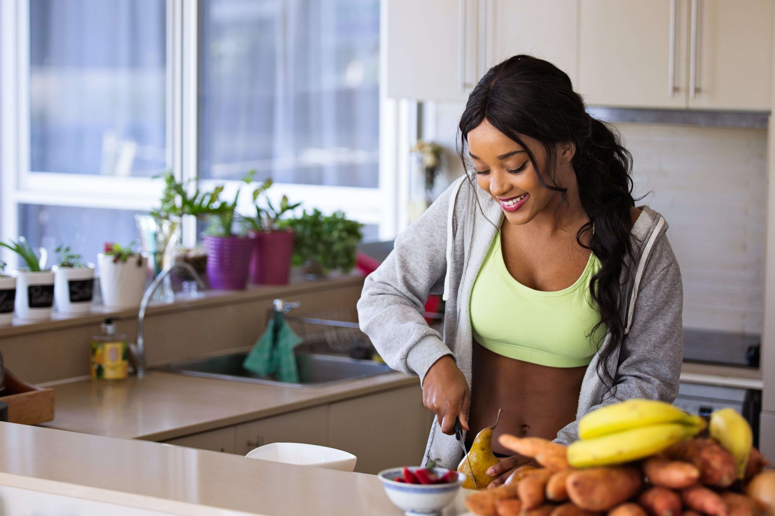 fille qui coupe des fruits et légumes pour un jus détox